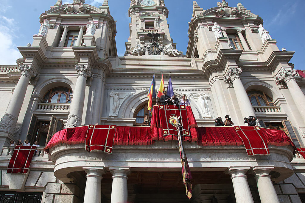 Флаг Валенсийского сообщества с достоинством опускают с главного балкона Городской Ратуши Валенсии, чтобы с гордостью пройти по центральным улицам города Валенсия к памятнику  Королю Хайме I